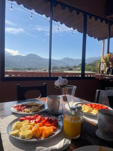 a table with plates of food and drinks on it at Dreams Lodge Orosi in Cartago