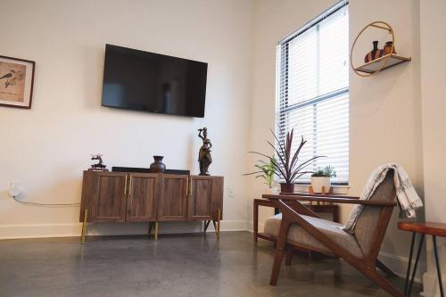 a living room with a table and a tv on the wall at Canyon Stop in Lawrence