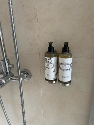 two bottles ofodorizers are sitting in a shower at Otília Apartamentos in Lisbon