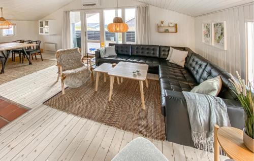 a living room with a black leather couch and a table at Holiday Home Arvidvej Iv in Bjerregård