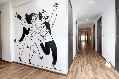 a wall mural of three women dancing in a hallway at Collection O Kk Trends in Vijayawada
