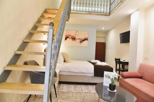 a bedroom with a bed and a staircase in a room at Pension 2Be in Nafplio