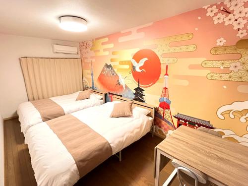 two beds in a room with a mural on the wall at Camelot Annex in Fukuoka