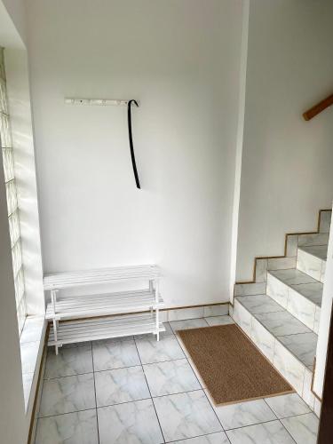 a white room with stairs and a rug at Ubytovani v Beskydech in Bystrzyca