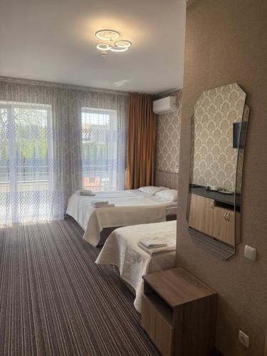 a hotel room with two beds and a mirror at Motel Kurortnyy & SPA in Shklo