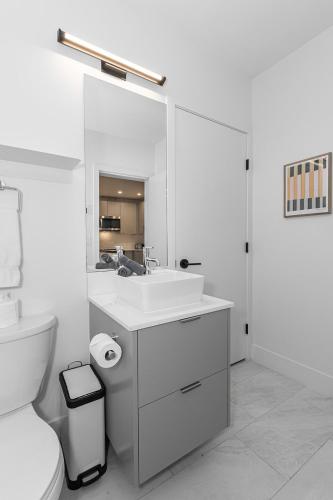 a white bathroom with a sink and a toilet at Tally Ho by Revelstoke Vacations in Revelstoke