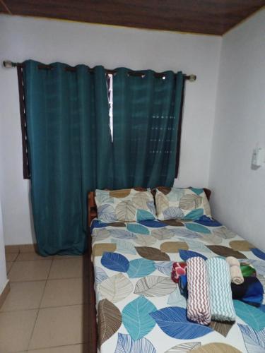 a bedroom with a bed with a green curtain at Adinam's Beach Retreat in Nyanyanu