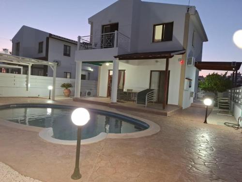 a villa with a swimming pool in front of a house at Marmario Villa 10 in Anarita