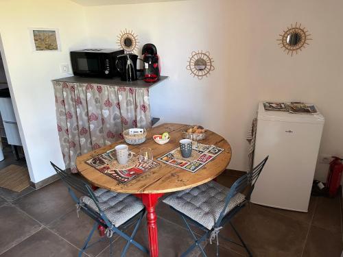 d'une table, de chaises et d'un four micro-ondes. dans l'établissement Le Pigeonnier de coupiac, à Gourdon