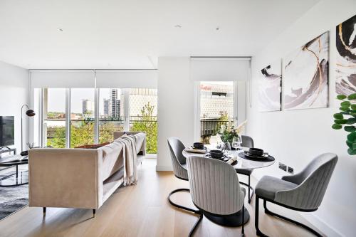 a living room with a table and chairs at Luxurious White City Apartment - Balcony & View in London