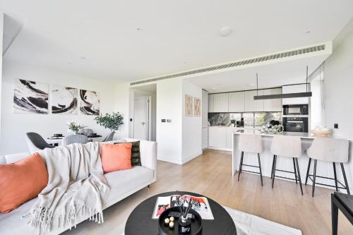 a living room with a couch and a table at Luxurious White City Apartment - Balcony & View in London