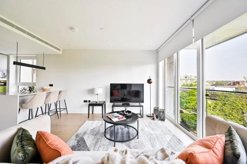 a living room with a couch and a table at Luxurious White City Apartment - Balcony & View in London