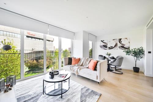 a living room with a couch and a table at Luxurious White City Apartment - Balcony & View in London