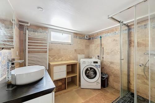 une salle de bain avec une machine à laver et un lavabo dans l'établissement Cosy house with garden near Paris, à Alfortville