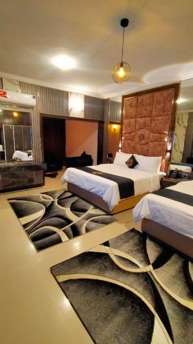 a hotel room with two beds and a carpet at Hotel Oasis in Islamabad