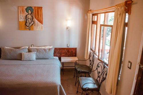 sypialnia z łóżkiem i oknem w obiekcie Hotel y Restaurant Embajadoras w mieście Guanajuato