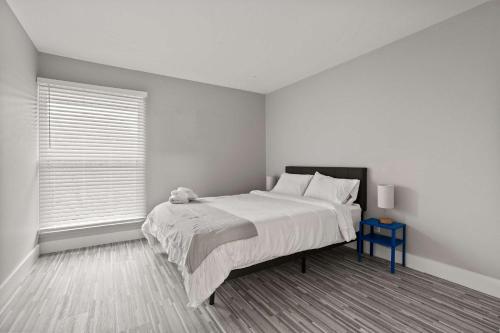 a white bedroom with a large bed and a window at Stylish & Spacious Getaway Near Downtown in Rochester Hills