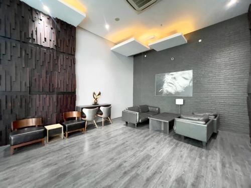 ein Wartezimmer mit Sofas, Stühlen und einer Wand in der Unterkunft apartemen brooklyn alsut Studio bergaya modern,pusatkota,cozy,pool,gym,wifi in Dongkal Dua