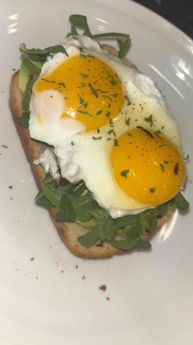 a sandwich with two eggs on a white plate at Wyndham Garden Sacramento Airport Natomas in Sacramento
