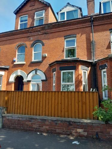 an old brick house with a wooden fence at Monarch House in Manchester