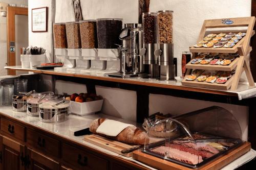 a bakery counter with a bunch of different types of food at Hotel Chalet Swiss in Interlaken