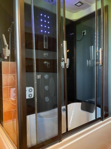 a glass shower in a bathroom with a tub at Apartament DOLOMITI in Jaworki