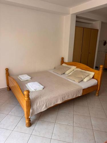 a wooden bed with two towels on top of it at ANORA Apartments in Becici