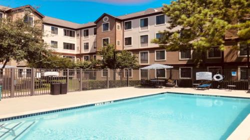 a swimming pool in the courtyard of a apartment building at Staybridge Suites Houston West - Energy Corridor by IHG in Houston