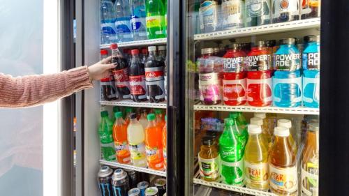 a person is reaching into a refrigerator full of drinks at Staybridge Suites Houston West - Energy Corridor by IHG in Houston