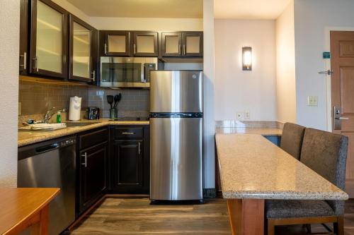 a kitchen with a stainless steel refrigerator in it at Staybridge Suites Houston West - Energy Corridor by IHG in Houston