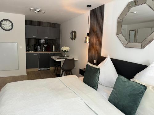 a bedroom with a bed and a mirror and a kitchen at Prime Host Dream in Karlsruhe