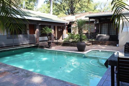 a swimming pool in front of a house at Royal Game Guest House in Phalaborwa