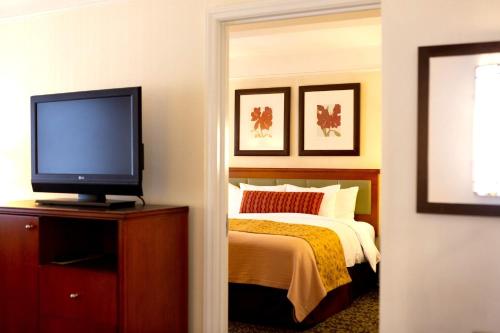 a bedroom with a bed and a flat screen tv at San Carlos Hotel New York in New York