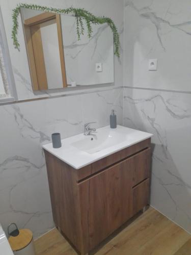 a bathroom with a sink and a mirror at Encanto da Aldeia in Torre de Moncorvo