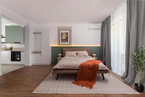 a bedroom with a bed with an orange blanket on it at Hubix Suites - City of Mara in Timişoara
