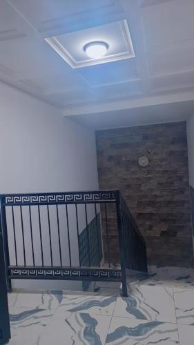 a ceiling with a staircase and a stone wall at Aloha Suites Odza - by Skyline Residence Services in Yaoundé