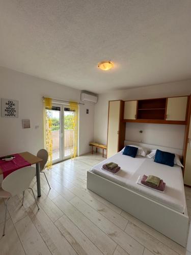 a bedroom with a large white bed and a table at Villa Nedo in Baška Voda