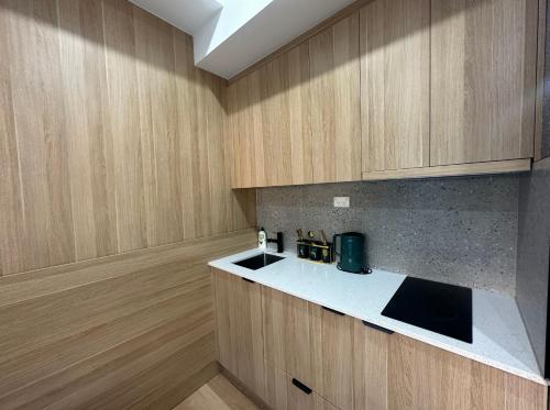 a kitchen with wooden cabinets and a white counter top at Sydney Premium Studio Renovated 2025 in Sydney