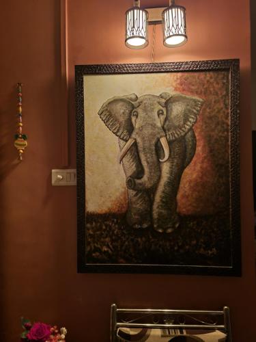 a painting of an elephant hanging on a wall at Aayushi Homestay Ratnagiri in Math