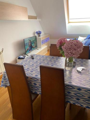 a dining room table with a vase of flowers on it at MAR y MONTE BURELA in Burela de Cabo
