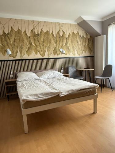 a bedroom with a bed and a wall with leaves at Pensjonat Wiktoria in Międzywodzie