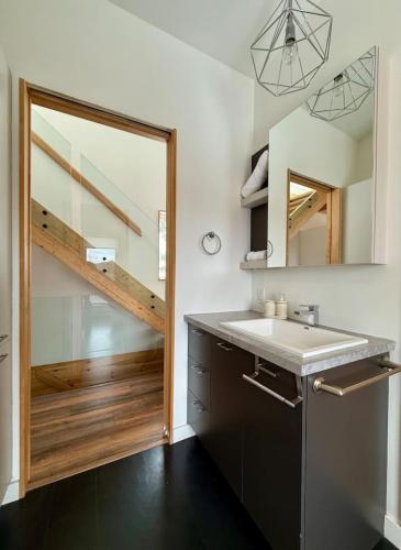a bathroom with a sink and a mirror at Chalet aux ℳille et une vues in Petite-Rivière-Saint-François