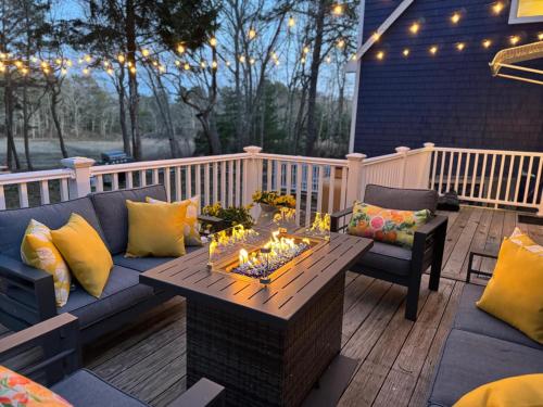 a patio with a couch and a table with fires at Riverfront Retreat in Wareham in Wareham