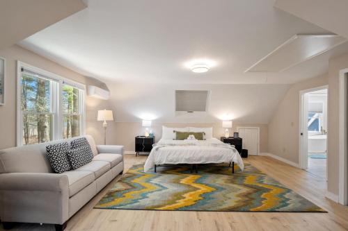 a white bedroom with a bed and a couch at Riverfront Retreat in Wareham in Wareham