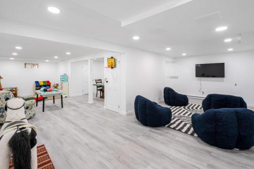 a living room with blue chairs and a flat screen tv at Riverfront Retreat in Wareham in Wareham
