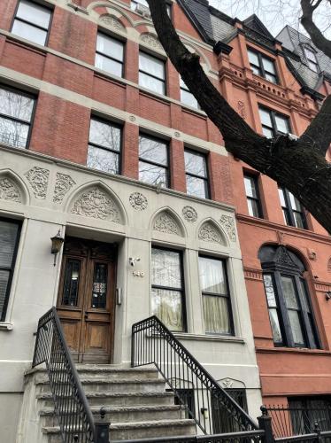 a brick building with stairs leading to a door at NYC Townhouse Apartment in New York