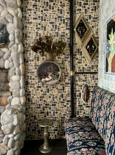 a room with a tiled wall with a couch and a vase at NYC Townhouse Apartment in New York