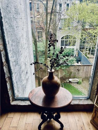 a vase sitting on a table in front of a window at NYC Townhouse Apartment in New York