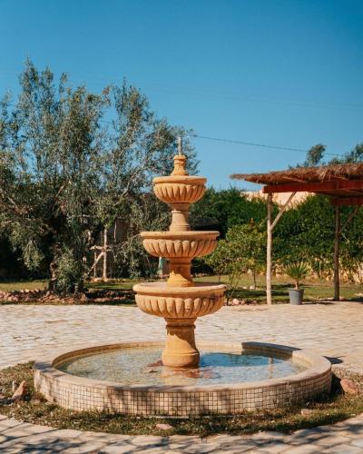 a large fountain in a courtyard with water in it at Villa l'Olivier d'Or, Un havre de nature, à deux pas de la mer in Akouda