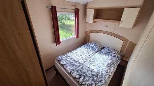 a small room with a bed in a trailer at kraina jezior in Skorochow